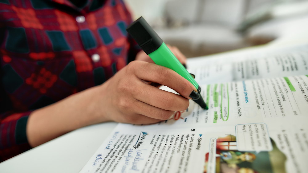 Student highlighting a textbook