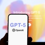 Smartphone showing GPT-5 OpenAI logo in front of a blurred screen with 'Introducing GPT-5' text, symbolizing ChatGPT 5 release, AI news, ChatGPT update, and AI for education advancements.